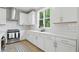 Well-lit kitchen with white cabinetry, stainless steel appliances, and wood-look flooring at 16244 Perrault Ct, Fishers, IN 46040