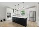 Modern kitchen with white cabinets, black island, stainless steel appliances and great lighting at 16244 Perrault Ct, Fishers, IN 46040