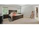 Spacious main bedroom with a wooden bed frame, neutral tones, and natural light from large windows at 16244 Perrault Ct, Fishers, IN 46040