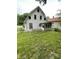 The back of a two-story white house reveals a small enclosed porch and a spacious grassy yard at 1630 E 18Th St, Indianapolis, IN 46218