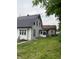 The back of a two-story white house reveals a small enclosed porch and a spacious grassy yard at 1630 E 18Th St, Indianapolis, IN 46218