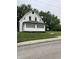 A white house with a front porch and green lawn shows the property's curb appeal at 1630 E 18Th St, Indianapolis, IN 46218