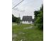 A quaint white house showcases a large roof and expansive front lawn at 1630 E 18Th St, Indianapolis, IN 46218