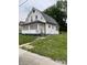 A white house with a front porch and green lawn shows the property's curb appeal at 1630 E 18Th St, Indianapolis, IN 46218