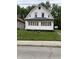 A white house with a front porch and green lawn shows the property's curb appeal at 1630 E 18Th St, Indianapolis, IN 46218