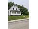 A white house with a front porch and green lawn shows the property's curb appeal at 1630 E 18Th St, Indianapolis, IN 46218