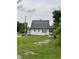 A quaint white house showcases a large roof and expansive front lawn at 1630 E 18Th St, Indianapolis, IN 46218