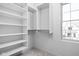 Spacious walk-in closet with shelving, hanging rods, and a bright window for natural light at 1655 Fernley Dr, Westfield, IN 46074