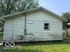 Rear view of the home featuring neutral siding, a window, and a green lawn at 1720 E Cornell Ave, Muncie, IN 47303