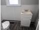 Compact bathroom with a white vanity, toilet, and tiled walls at 1720 E Cornell Ave, Muncie, IN 47303
