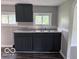 Charming kitchen features dark cabinets, gray countertop, stainless steel sink, and multiple windows at 1720 E Cornell Ave, Muncie, IN 47303