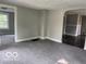 Carpeted living room view showcasing an open layout and natural lighting at 1720 E Cornell Ave, Muncie, IN 47303