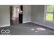 View of the living room with carpet and a glimpse into the adjacent kitchen area at 1720 E Cornell Ave, Muncie, IN 47303