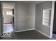 Carpeted living room, showing built-in shelving and a glimpse into the kitchen area at 1720 E Cornell Ave, Muncie, IN 47303