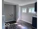 Open room with wood-look floors, gray walls, a laundry hook up, a window, and modern finishes at 1720 E Cornell Ave, Muncie, IN 47303