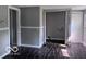 The room features wood-look floors, gray walls, a laundry area, a door, and windows at 1720 E Cornell Ave, Muncie, IN 47303