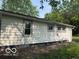 View of the home exterior featuring neutral siding, trimmed windows, and a green lawn at 1720 E Cornell Ave, Muncie, IN 47303