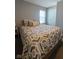 Cozy bedroom with a patterned comforter and a side table, brightened by natural light at 17255 Seaboard Pl, Noblesville, IN 46060