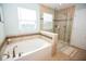 Inviting bathroom featuring a soaking tub, glass-enclosed shower, and tiled walls at 18297 Rickety Dr, Westfield, IN 46074