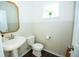 Bright powder room featuring a pedestal sink, wood-look floors, and decorative wall paneling at 18297 Rickety Dr, Westfield, IN 46074