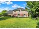 Large, green backyard featuring a well-manicured lawn, a spacious deck, and mature trees at 1898 Corniche Dr, Zionsville, IN 46077