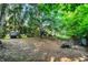 Secluded backyard with mature trees, bench, playhouse, firepit, and wrought iron fence at 1898 Corniche Dr, Zionsville, IN 46077