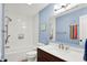 Bright bathroom with blue walls features a shower over tub, dark wood vanity, and white subway tiles at 1898 Corniche Dr, Zionsville, IN 46077