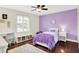 Charming bedroom features a colorful purple accent wall, hardwood floors, and a whimsical area rug at 1898 Corniche Dr, Zionsville, IN 46077