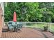 Spacious wooden deck features an outdoor dining set, an umbrella, and lots of green trees at 1898 Corniche Dr, Zionsville, IN 46077