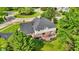Aerial view of brick home with a backyard deck, surrounded by lush green landscaping and mature trees at 1898 Corniche Dr, Zionsville, IN 46077