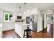 Bright kitchen featuring white cabinets, stainless steel appliances, an island with seating, and hardwood floors at 1898 Corniche Dr, Zionsville, IN 46077