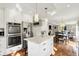 Bright kitchen with stainless steel appliances, an island with seating, and an open layout with hardwood floors at 1898 Corniche Dr, Zionsville, IN 46077