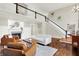 Open-concept living room with hardwood floors, fireplace, wainscotting, and a staircase at 1898 Corniche Dr, Zionsville, IN 46077