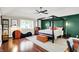 Elegant main bedroom with dark four-poster bed, green accent wall, and stylish chaise lounge at 1898 Corniche Dr, Zionsville, IN 46077