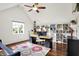 Bright office with vaulted ceilings featuring hardwood floors, custom bookshelves, and a ceiling fan at 1898 Corniche Dr, Zionsville, IN 46077
