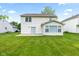 View of the house's back exterior showcases a sunroom addition and a spacious, green lawn at 1903 Windy Hill Ln, Indianapolis, IN 46239