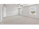 A spacious bedroom with neutral carpet, two windows, and a ceiling fan at 1903 Windy Hill Ln, Indianapolis, IN 46239