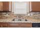 Kitchen detail of granite countertops, stainless steel dual sink, and tiled backsplash at 1903 Windy Hill Ln, Indianapolis, IN 46239
