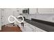 This is a kitchen featuring white cabinetry, stainless steel appliances, and dark countertops, blending style and functionality at 19146 Carol Cove Cir, Noblesville, IN 46062
