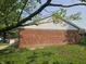 Side view of a brick home featuring white siding and trim, complemented by lush green lawn at 2017 Schwier Ct, Indianapolis, IN 46229