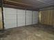 View of an empty, unfinished garage with wood paneling halfway up the walls and concrete floor at 2017 Schwier Ct, Indianapolis, IN 46229