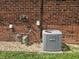Exterior brick wall and Armstrong HVAC unit surrounded by gravel and a small patch of grass at 2017 Schwier Ct, Indianapolis, IN 46229