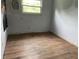 Empty bedroom has original wood flooring and a bright window at 206 E Hurdle Rd, Morgantown, IN 46160