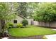 Spacious backyard with lush green lawn, mature trees, and a detached garage at 2158 S Garfield Dr, Indianapolis, IN 46203