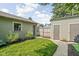 Detached garage with a fenced-in area, accessible via a grassy walkway and gate at 2158 S Garfield Dr, Indianapolis, IN 46203