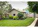 Detached garage surrounded by a beautiful, well-maintained garden and green lawn at 2158 S Garfield Dr, Indianapolis, IN 46203