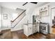 Well-lit kitchen featuring modern appliances, an island sink, and staircase at 2158 S Garfield Dr, Indianapolis, IN 46203