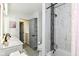 Well-lit bathroom with a double vanity, a decorative shower with gray accent tiles, and neutral color scheme at 2433 Hideaway S Dr, Indianapolis, IN 46268