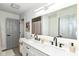 Bright bathroom featuring a double vanity with modern fixtures, a large mirror, and a shower-tub combination at 2433 Hideaway S Dr, Indianapolis, IN 46268