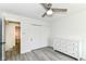 Bright bedroom featuring a ceiling fan, gray flooring, a double-door closet, and white dresser with ample storage at 2433 Hideaway S Dr, Indianapolis, IN 46268